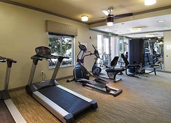 a gym with treadmills and other exercise equipment in a building