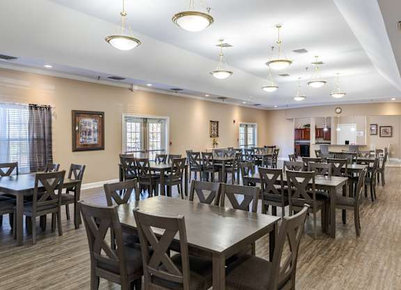 A large room with tables and chairs and a TV.at The Gardens of Stafford, Stafford, VA  