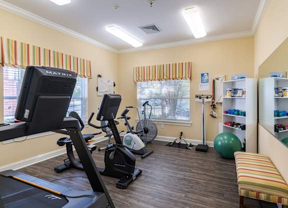 A gym with a treadmill, exercise bike, and other equipment.at The Gardens of Stafford, Virginia, 22556
