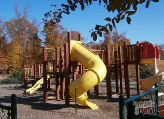 A playground with a yellow slide and a red slide.at The Village at England Run, Fredericksburg, Virginia  