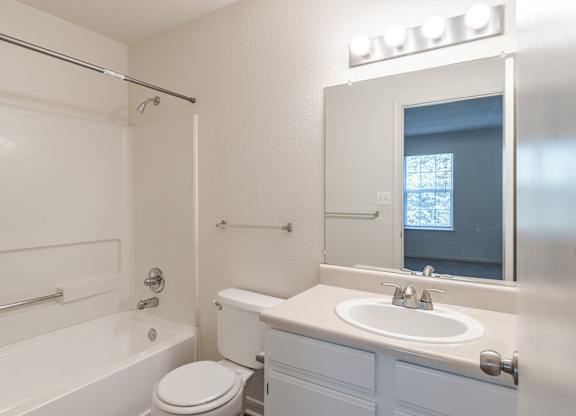A white bathroom with a toilet, sink, and bathtub.at The Village at England Run, Virginia, 22406