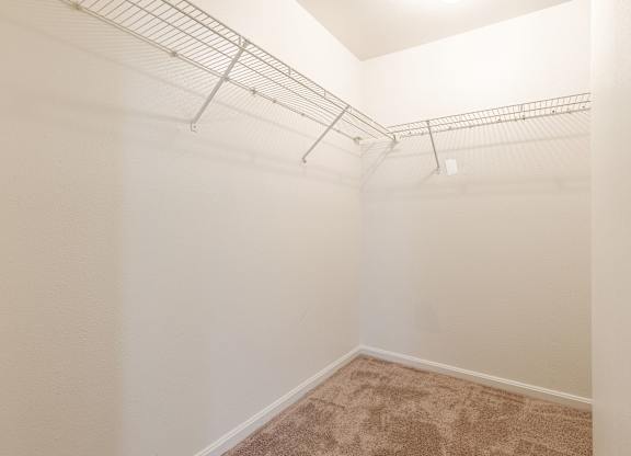 an empty closet in a bedroom with a shelf on the wall