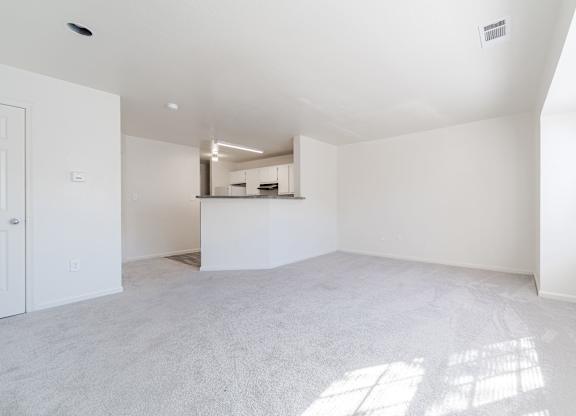 the living room and kitchen in a new home with white walls and flooring
