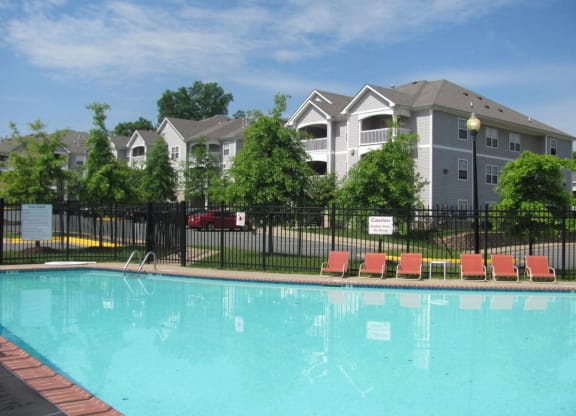 a swimming pool with apartment buildings in the background at Woodwind Villa, Woodbridge, VA 22191