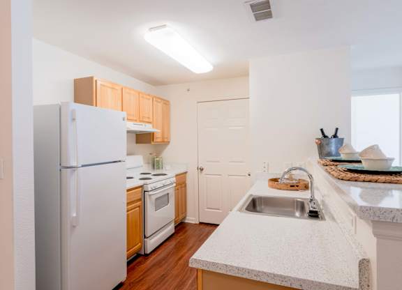 A kitchen with a white refrigerator, sink, and cabinets.at Woodwind Villa Apartments, Woodbridge, VA 22191