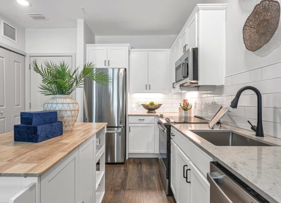 a kitchen with white cabinets and stainless steel appliances and a sink at Casa Marti, Tampa, 33605