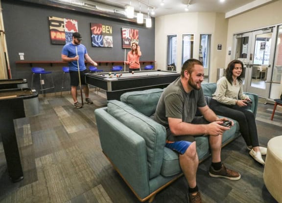 a group of people playing video games in a living room at Bluestone Lofts, Minnesota, 55803
