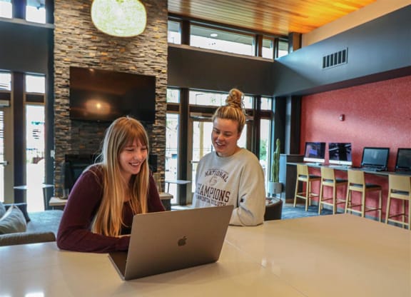 two women sitting at a table looking at a laptop computer at Bluestone Lofts, Duluth, 55803