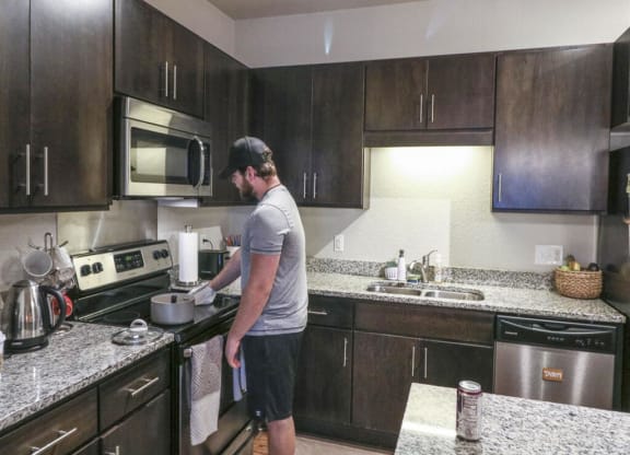 a man standing in a kitchen preparing food in a potat Bluestone Lofts, Minnesota