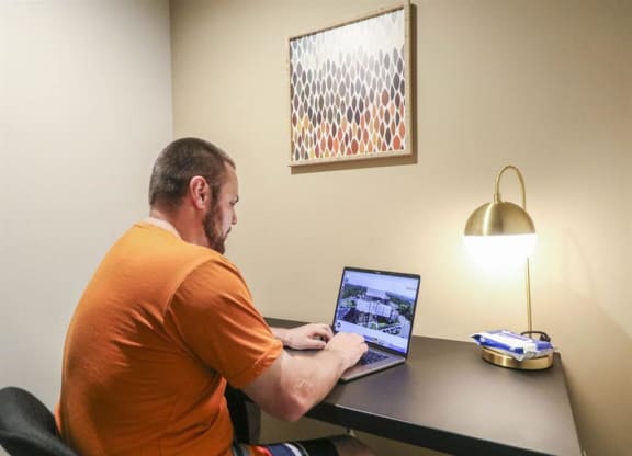 a man sitting at a desk using a laptop computer at Bluestone Lofts, Duluth Minnesota
