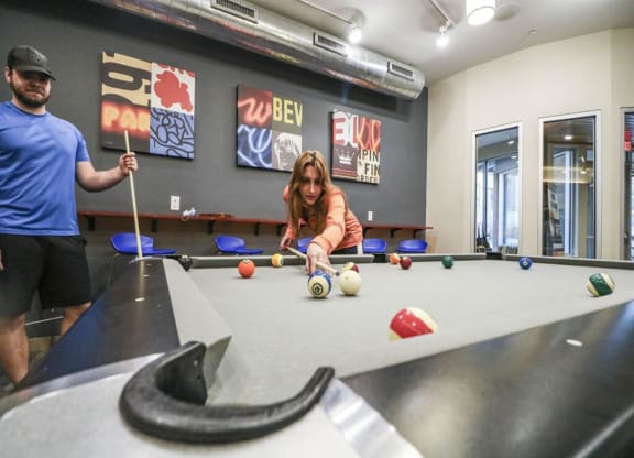 a man and a woman playing pool at a table at Bluestone Lofts, Duluth