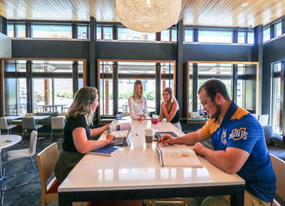 a group of people sitting around a table in a library at Bluestone Lofts, Minnesota, 55803