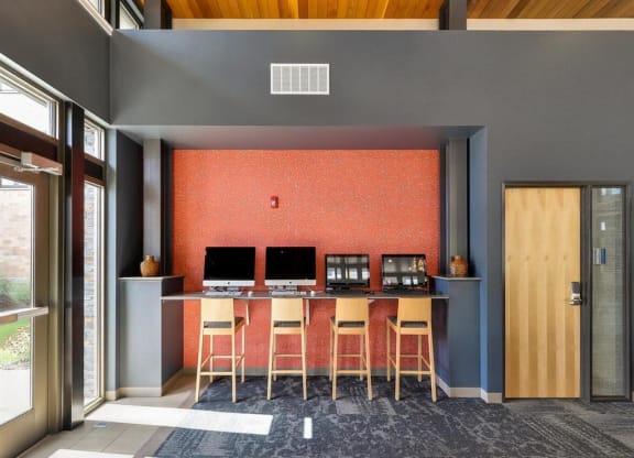 a desk with three monitors in a room with chairs at Bluestone Lofts, Duluth, MN