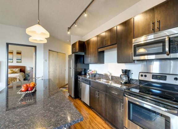 a kitchen with stainless steel appliances and granite counter tops at Bluestone Lofts, Duluth, 55803