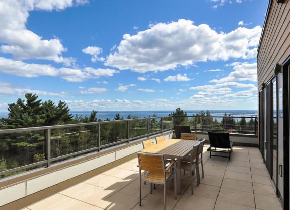 a patio with a table and chairs on a balcony overlooking the oceanat Bluestone Lofts, Duluth, 55803