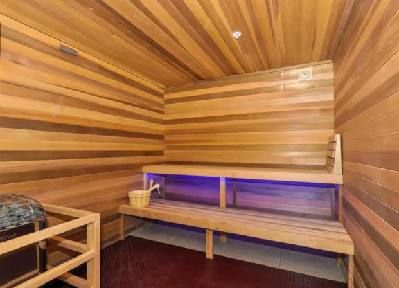 a small sauna with a bench and a bucket at Bluestone Lofts, Minnesota, 55803