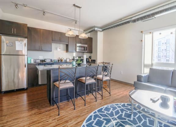 a living room with a kitchen and a table with chairs