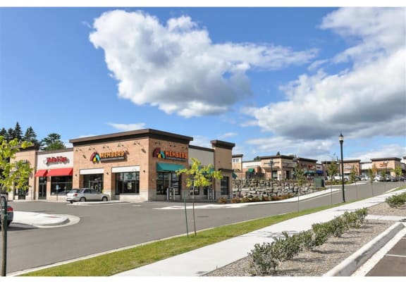 a shopping center with stores and a parking lot at Bluestone Lofts, Minnesota, 55803