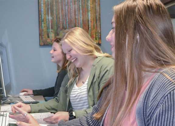three women sitting at a desk working on computers at Boulder Ridge, Duluth, MN 55811