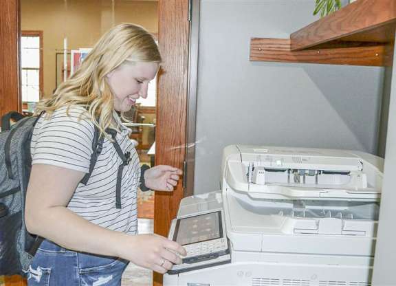 a woman is standing next to a fax machine at Boulder Ridge, Minnesota, 55811