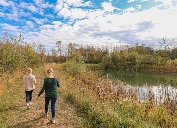 two women walking along a trail next to a lake at Boulder Ridge, Minnesota