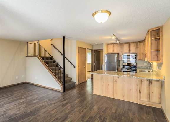 a living room with a kitchen and a staircase at Campus Park, Duluth, MN, 55811