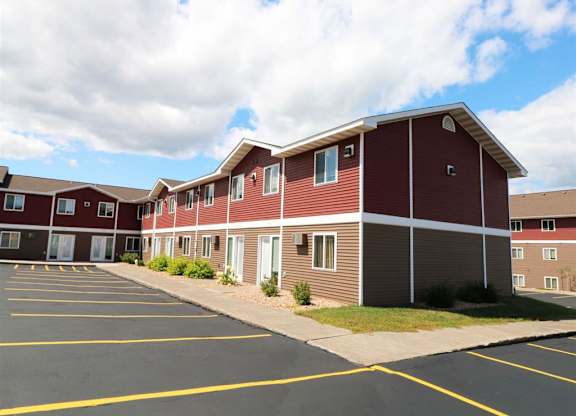 a row of red buildings with a parking lot at Campus Park, Minnesota