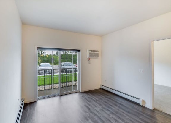 an empty living room with a door to a balcony at Arbor Ridge, Forest Lake, MN