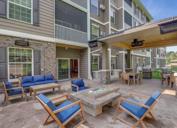 an outside patio with chairs and tables and a fire pit at Arbor Ridge, Forest Lake, 55025