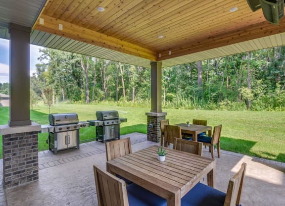 a covered patio with tables and barbecue grill at Arbor Ridge, Forest Lake, MN, 55025