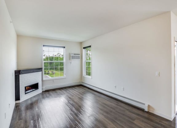 an empty living room with a fireplace and wooden floors at Arbor Ridge, Forest Lake, MN, 55025