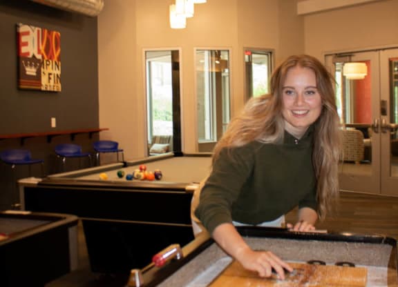 a young woman standing at a pool table at Bluestone Lofts, Duluth, MN, 55803