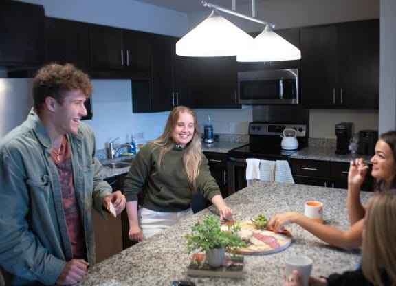 a group of people standing around a kitchen counter at Bluestone Lofts, Duluth, MN