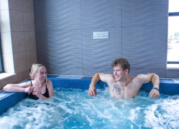 a man and a woman in an indoor swimming pool at Bluestone Lofts, Duluth