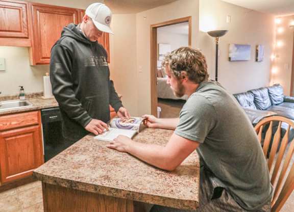 two men are sitting at a kitchen counter at Boulder Ridge, Minnesota