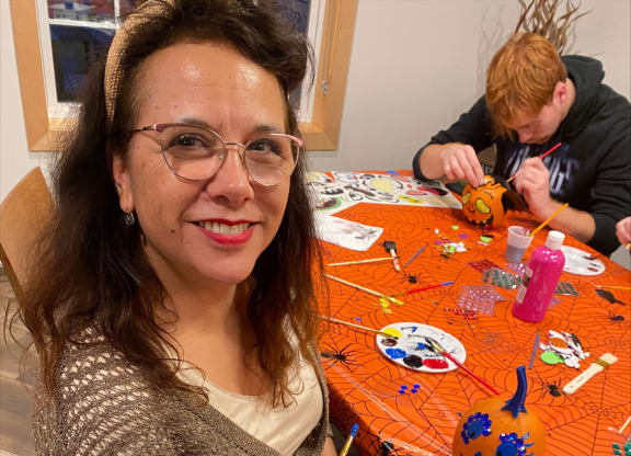 a woman is painting a pumpkin on a table with a boy  at Timber Ridge, Forest Lake, MN