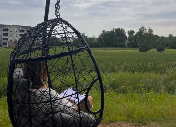 a child is sitting in a bird cage on a swing  at Timber Ridge, Forest Lake, MN, 55025