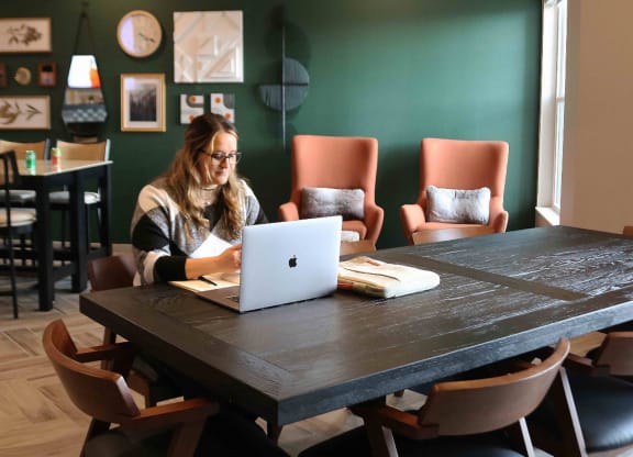 a woman sitting at a table with a laptop computer  at Timber Ridge, Forest Lake, 55025