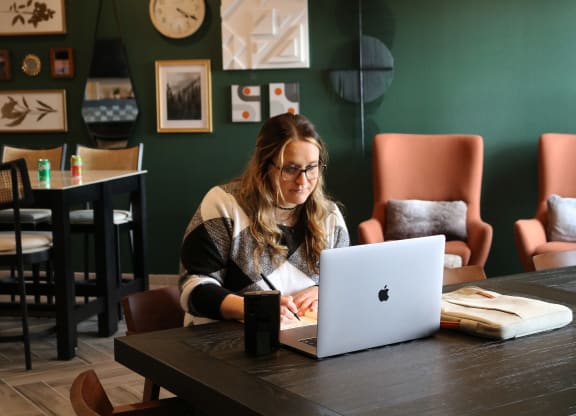 a woman sitting at a table using a laptop computer  at Timber Ridge, Forest Lake