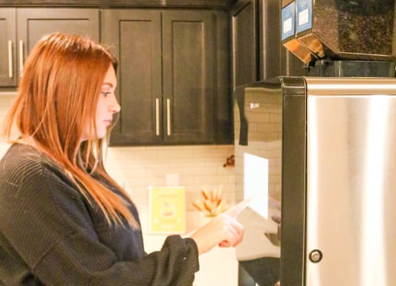 a woman standing in a kitchen putting food into a refrigerator  at Timber Ridge, Minnesota, 55025