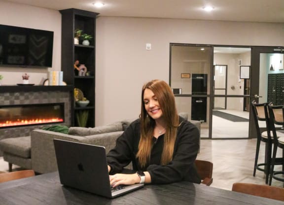 a woman sitting at a table with a laptop computer  at Timber Ridge, Minnesota, 55025