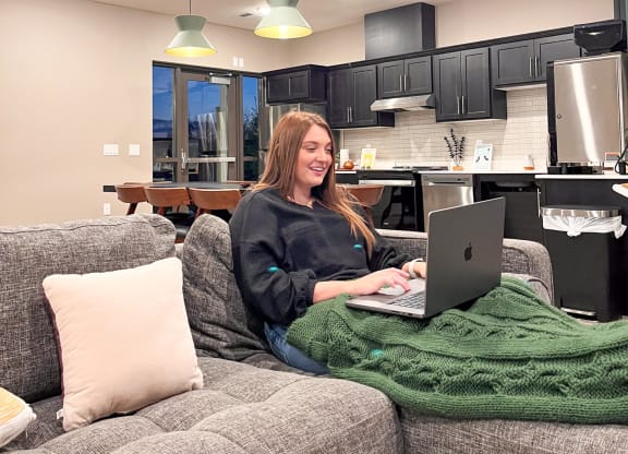 a woman sitting on a couch using a laptop computer  at Timber Ridge, Minnesota, 55025