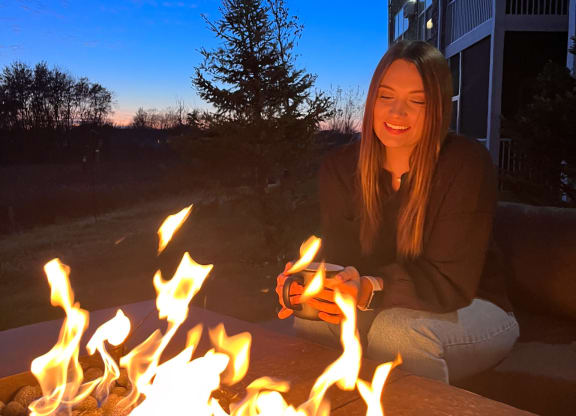 a woman sitting in front of a fire pit  at Timber Ridge, Minnesota