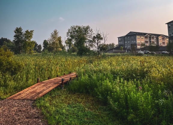 a wooden bridge in a field with a building in the background  at Timber Ridge, Minnesota, 55025