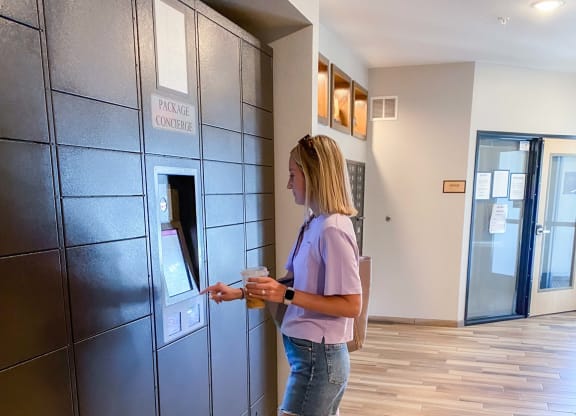 a woman picking up her package in the lobby  at Timber Ridge, Forest Lake
