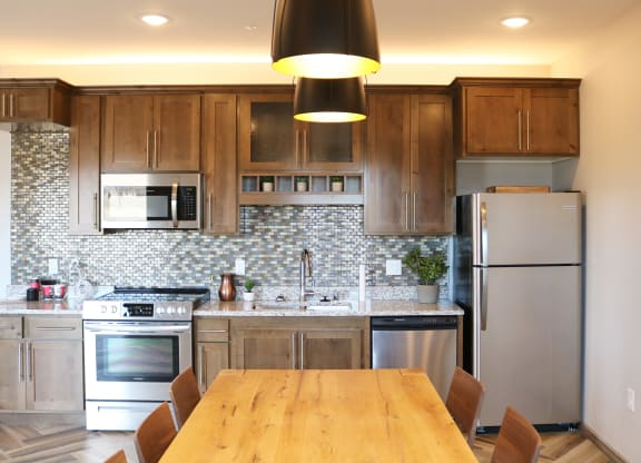 a kitchen with stainless steel appliances and a wooden table  at Timber Ridge, Minnesota, 55025