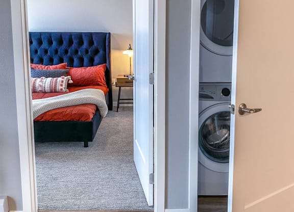 a bedroom with a bed and a washer and dryer in it  at Timber Ridge, Forest Lake