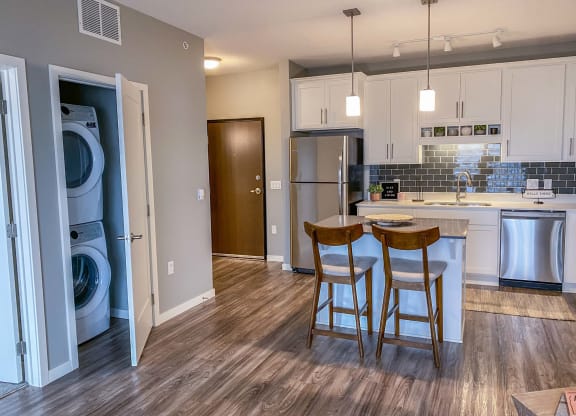 an open kitchen and dining area with white cabinets and wood floors  at Timber Ridge, Minnesota, 55025