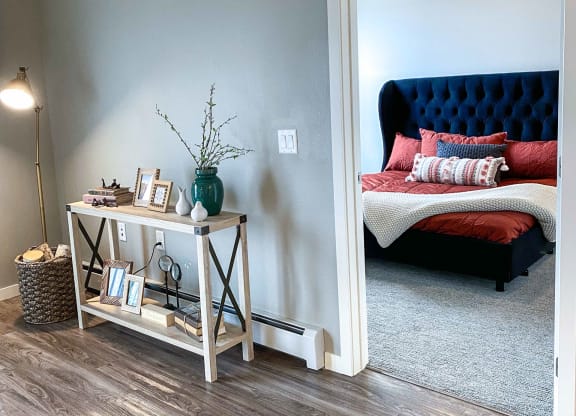 a bedroom with a bed and a white wall and wood floors  at Timber Ridge, Forest Lake, MN