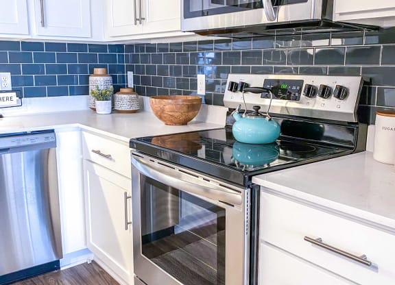 a kitchen with stainless steel appliances and white cabinets  at Timber Ridge, Minnesota, 55025